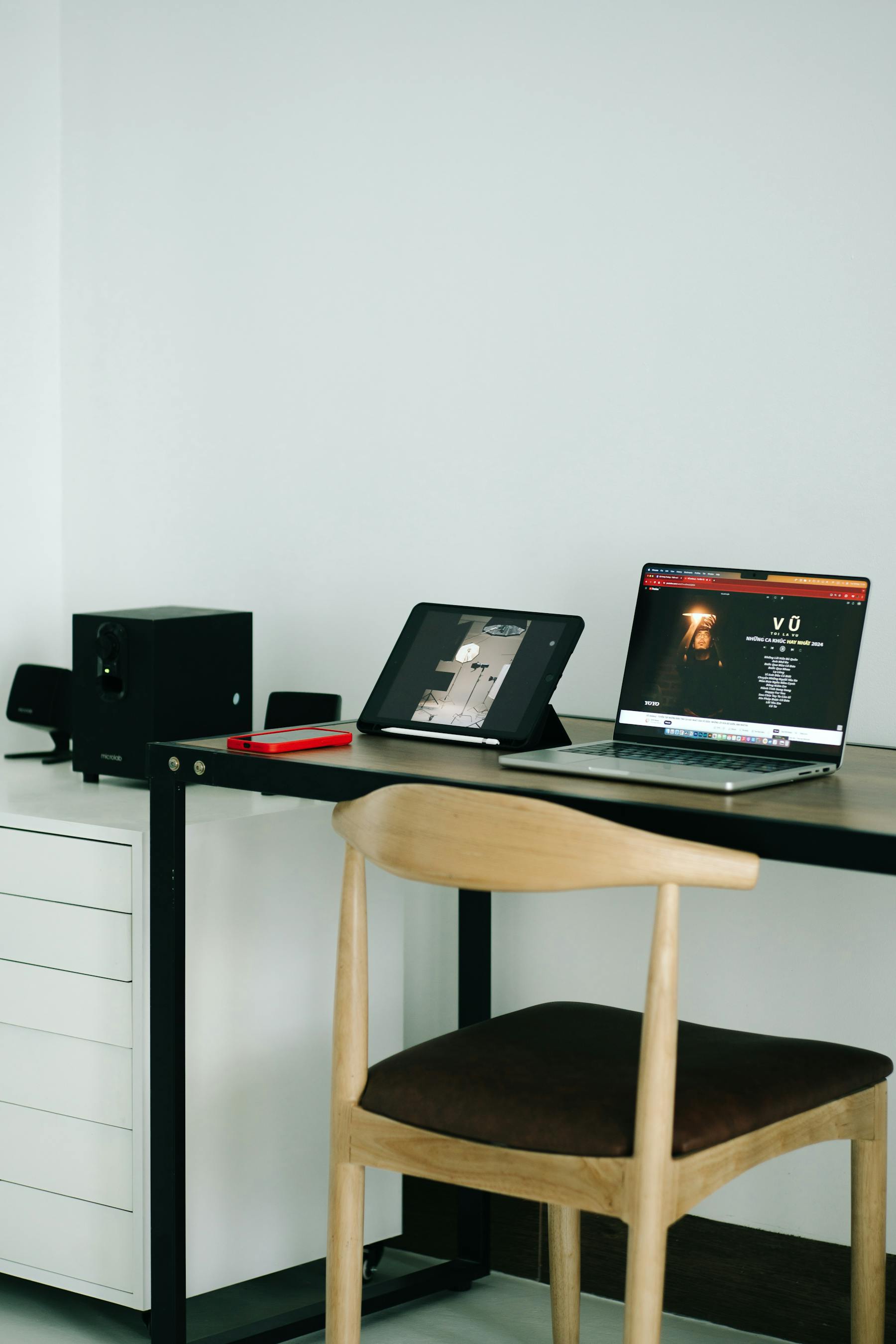 A clean desk setup with a laptop, tablet, and smartphone.